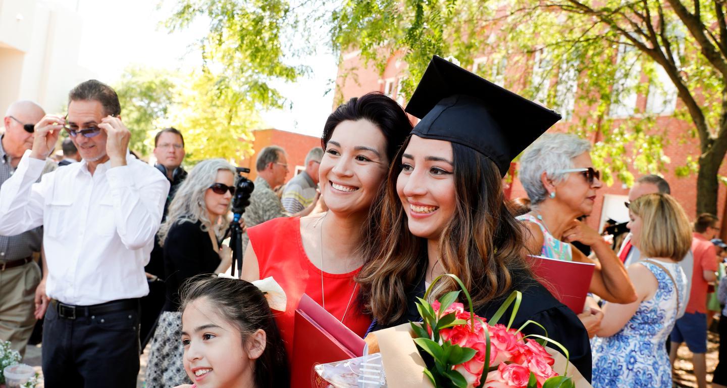 一位立博体育平台一等毕业生和她的母亲和姐姐在毕业典礼上.