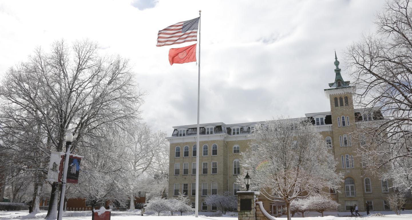 Old Main flying American Flag and College Flag in Winter